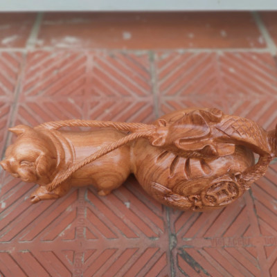 Tượng con heo kéo bao tiền bằng gỗ hương đá kt ngang 30cm